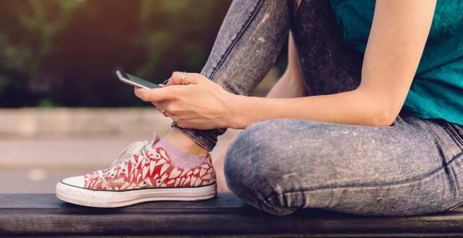 Young adult holding her mobile phone