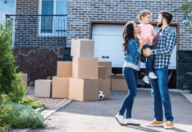 young first-time homebuyers smiling in front of new home