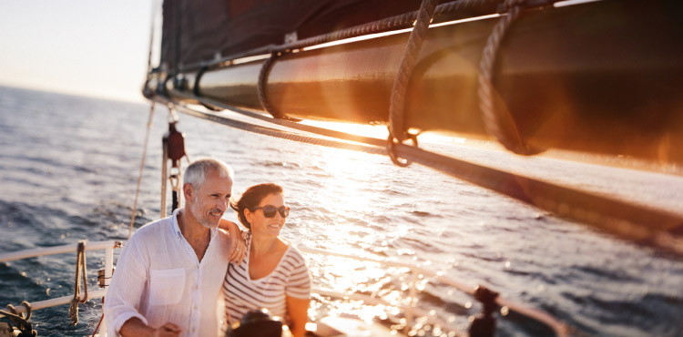 Mature couple look onward while they boat