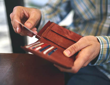 Man holding wallet getting card out for payment.