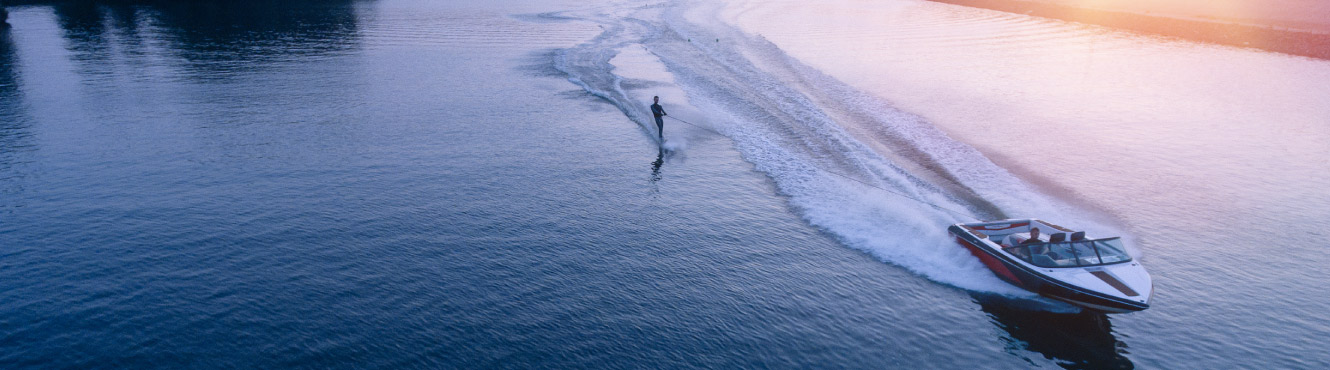 Water skier behind a boat at sunset