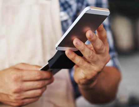 Business owner using chip reader to make payment.