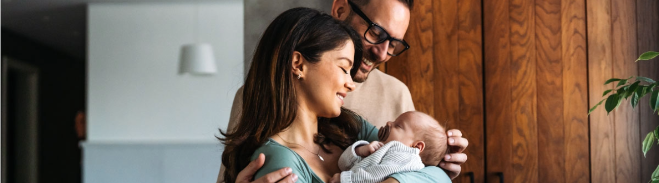 Couple looking at their infant and smiling