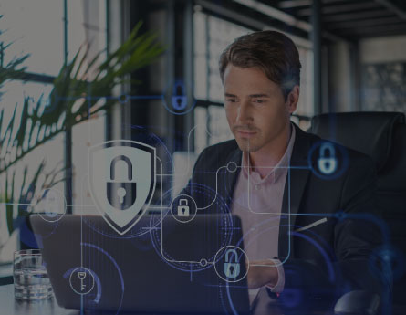 Man looking at laptop reviewing cybersecurity practices.