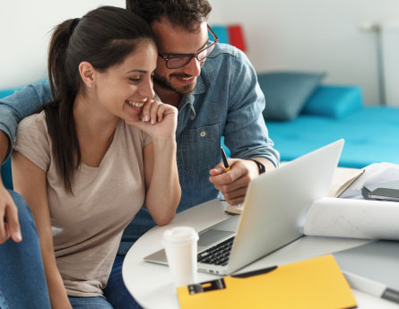 Couple on their laptop creating a savings plan together.