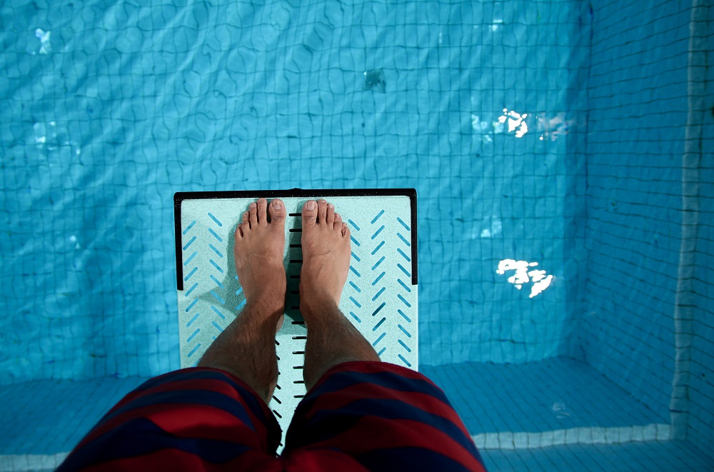 Looking down at swimming pool from diving board