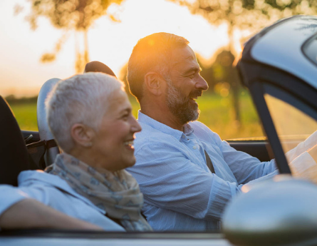 Retired couple driving in convertible