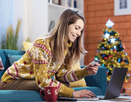 Person sitting on their couch using their Civista Debit Mastercard to shop online.