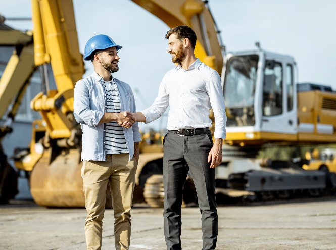 Men shaking hands, happy they secured funding for new commercial & aggregate equipment.