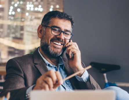 Man with glasses taking on phone in office