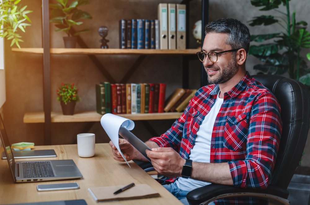 Man sitting at desk looking at notebook