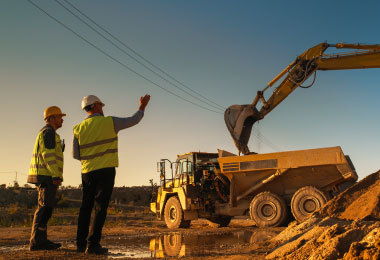 Contractors using their leased equipment to clear ground for building.