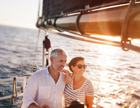 Retired couple sailing at sunset