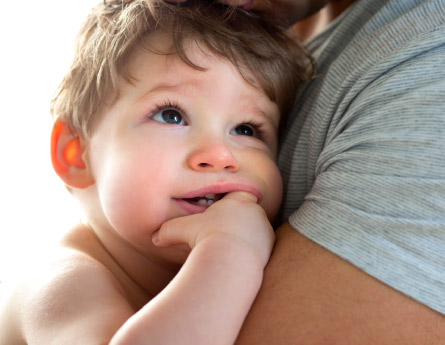 Father holds his baby boy in his arms