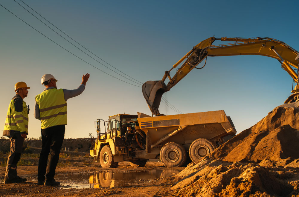 Contractors using their leased equipment to clear ground for building.