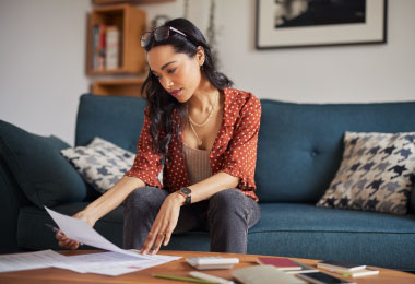 Woman reviewing and redoing her budget due to an emergency.