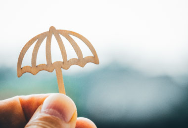 Hand holding an umbrella to protect from a storm