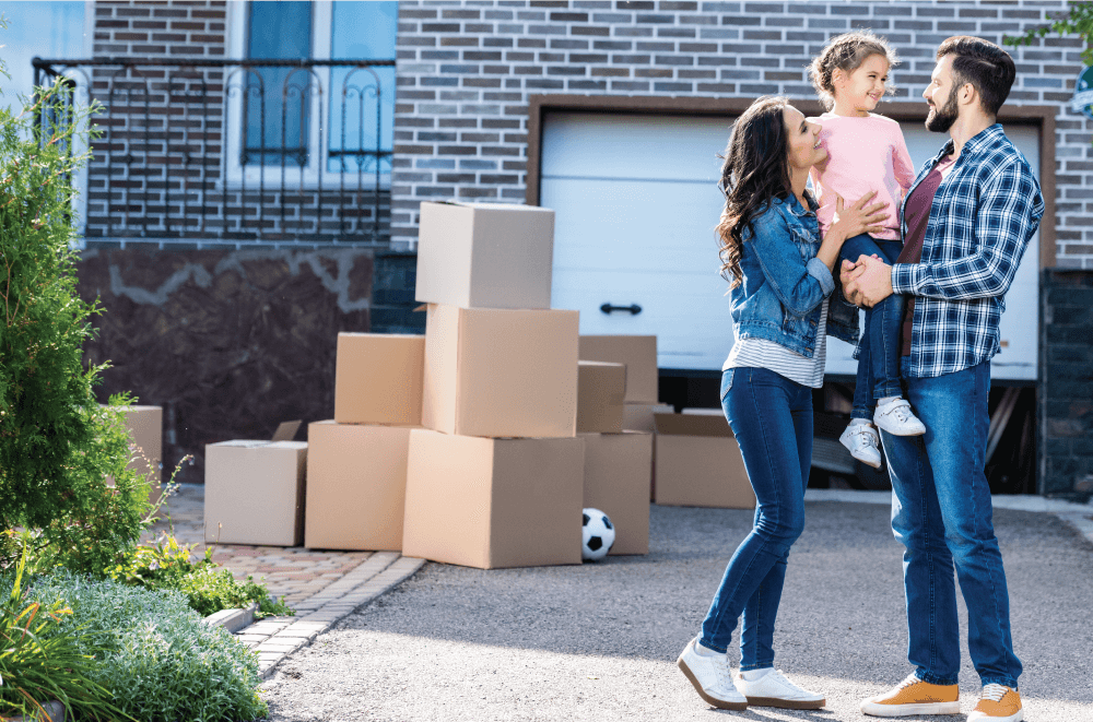 young first-time homebuyers smiling in front of new home