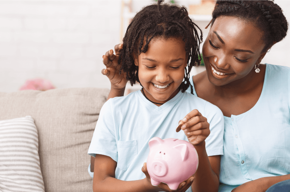 Mother helping daughter save money in piggy bank