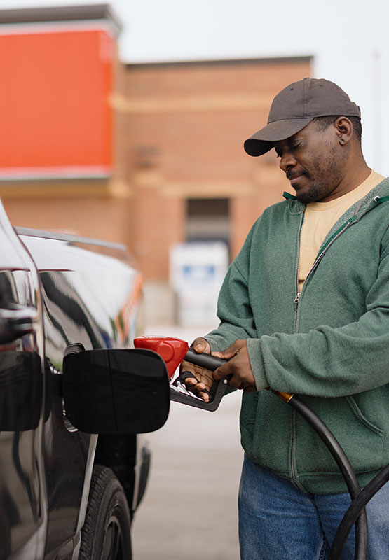 Man pumping gas as gas station