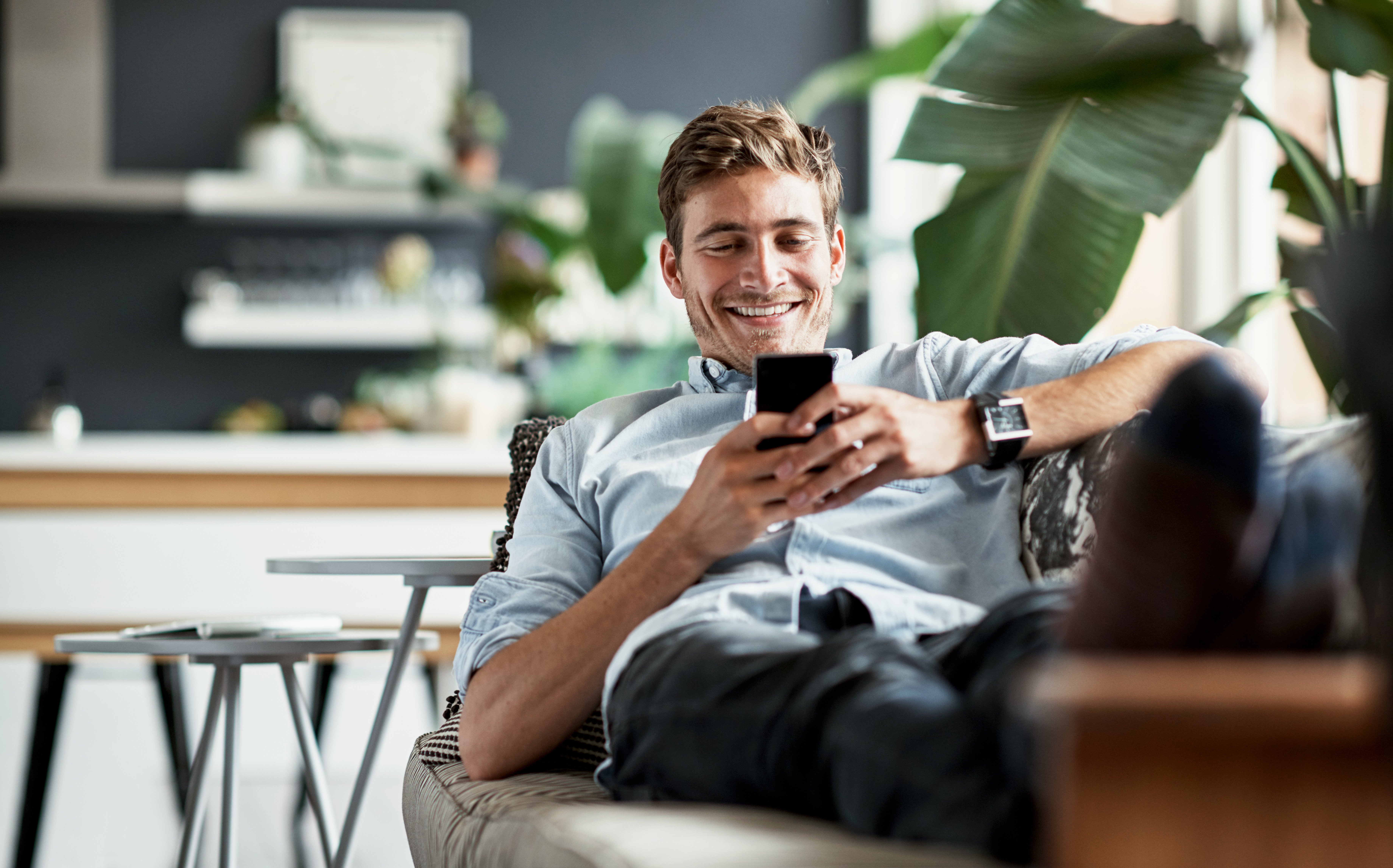 Man on couch using cell phone