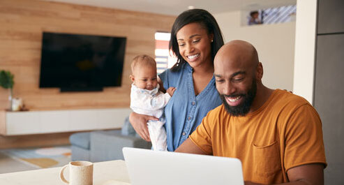 African-American-Family-With-Baby-Daughter-Using-Laptop-To-Check-Finances-At-Home