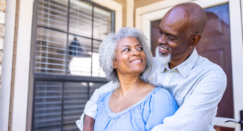 Mature couple in front of home
