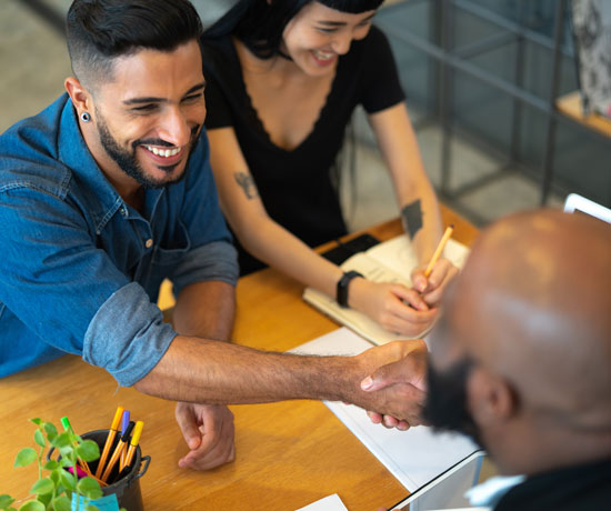 Couple meeting and shaking hands with banker